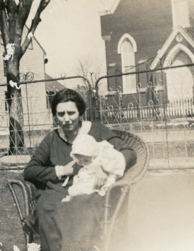 woman holding baby with St. James Catholic church in background