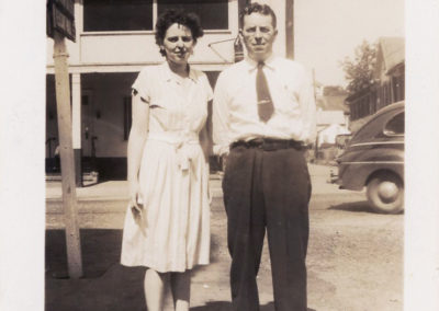 Mr. & Mrs. Zimmerman of Zimmerman's Cut Rate, standing at corner of Main and Potomac with hotel in background