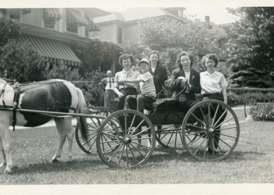 Horse-drawn buggy and family - North Main Street approximately where light is at Rt 66. Doug driving and various family members on board including his mother who is seated next to him.